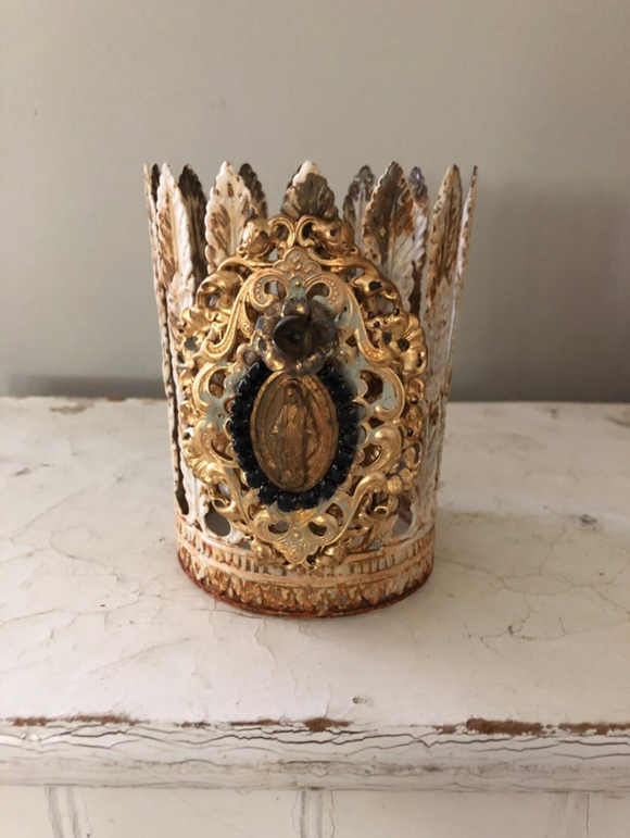 Feather leaf crown with Mary on front encircled with black rhinestones
