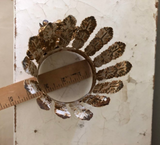 Feather leaf crown with Mary on front encircled with black rhinestones