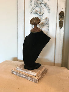 Black velvet jewelry display with aged metal rose and barn wood base