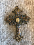 Metal cross with leaf filigree and small Mary on front