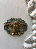 Cherub on a scroll wreath with 3 gold flowers