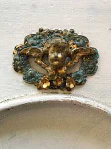 Cherub on a scroll wreath with 3 gold flowers