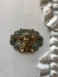 Cherub on a scroll wreath with 3 gold flowers